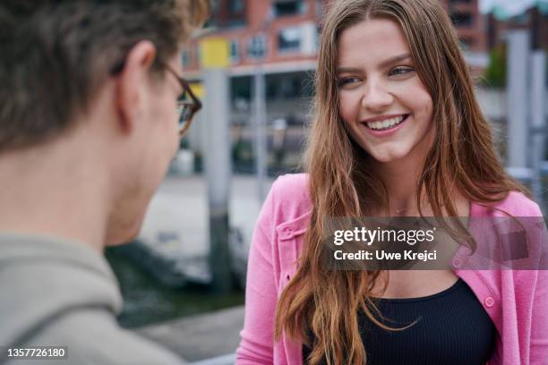 young woman and young man looking at each other - portrait woman men looking at each other stock-fotos und bilder