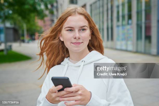 young woman holding phone - 18 19 anni foto e immagini stock