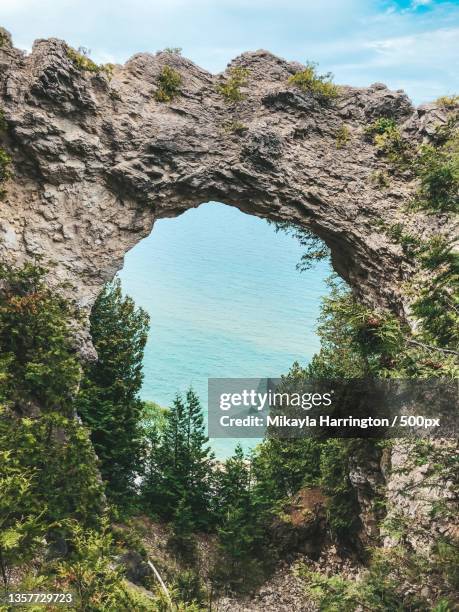 arched rock,low angle view of trees against sky,mackinac island,michigan,united states,usa - mackinac island ストックフォトと画像