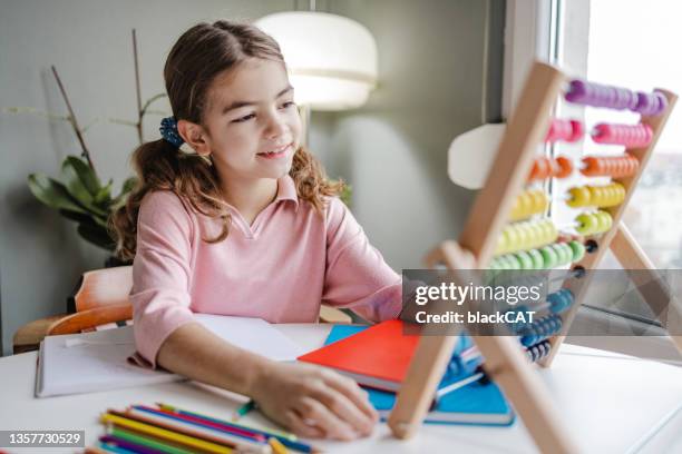 elementary school female uses abacus at home - mathematics imagens e fotografias de stock