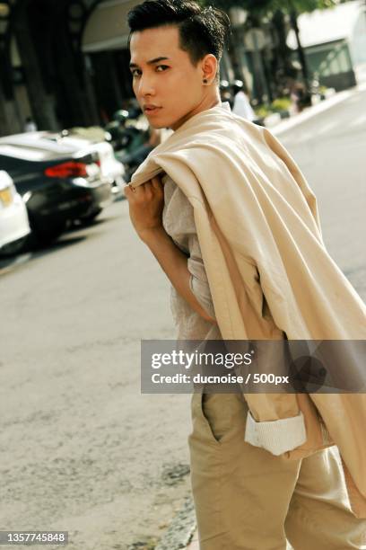 young man standing on street in city,vietnam - editorial style stock pictures, royalty-free photos & images