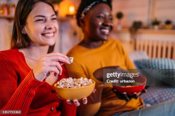 female roommates binge watch favorite tv series - binge tv stockfoto's en -beelden