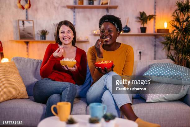 female roommates binge watch favorite tv series - binge tv stockfoto's en -beelden