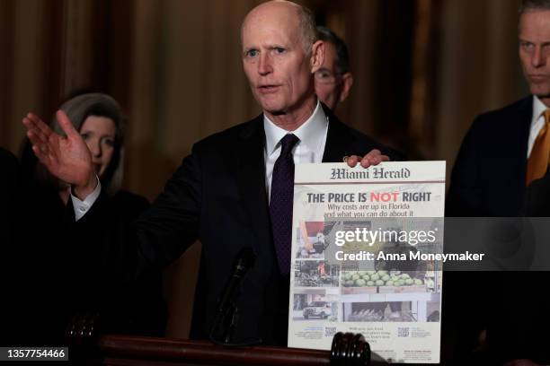 Sen. Rick Scott holds up a printed out copy of an edition of the Miami Herald as he speaks at a news conference after a weekly Republican policy...