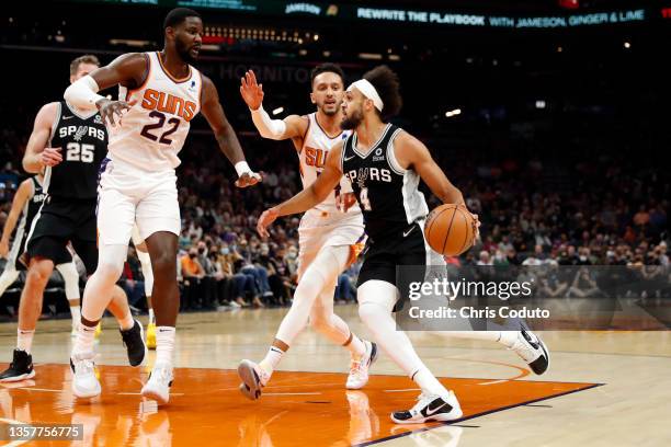 Deandre Ayton and Landry Shamet of the Phoenix Suns defend Derrick White of the San Antonio Spurs during the first half at Footprint Center on...