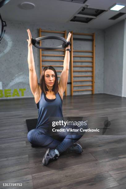 young woman exercising in the fitness studio - gym excercise ball stock pictures, royalty-free photos & images