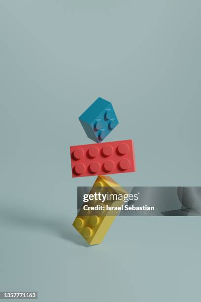 3d rendering illustra3d illustration of pink, blue and yellow building blocks balancing on top of each other on blue background.tion of rows of pink, blue and yellow building blocks on blue background. - baustein stock-fotos und bilder