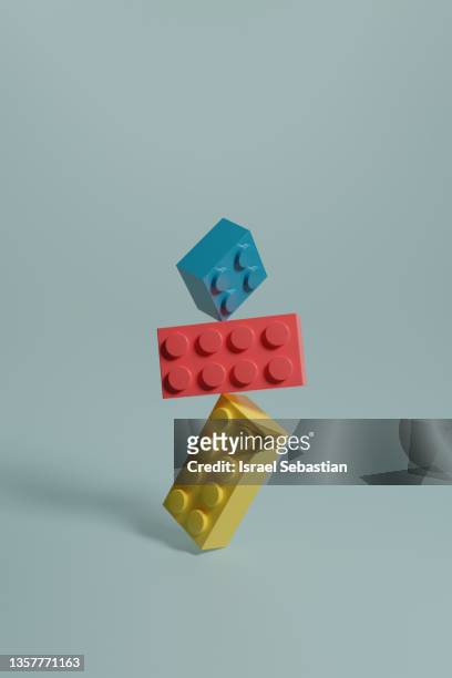 3d rendering illustra3d illustration of pink, blue and yellow building blocks balancing on top of each other on blue background.tion of rows of pink, blue and yellow building blocks on blue background. - baksteen stockfoto's en -beelden