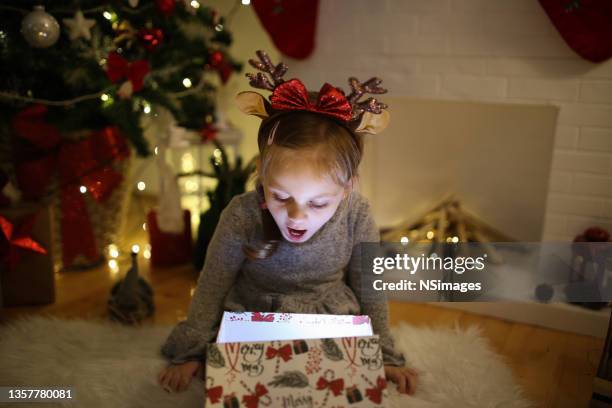 niña abriendo una mágica foto de archivo de regalo de navidad - giving a girl head fotografías e imágenes de stock