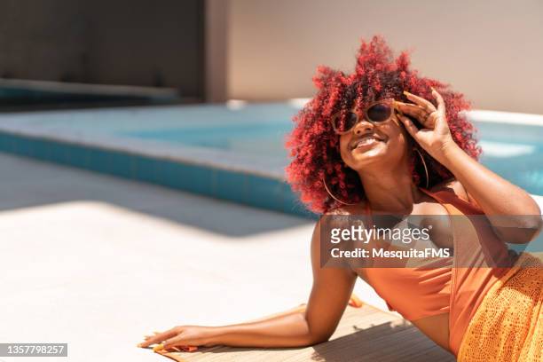 afro woman lying down sunbathing - dyed shades stock pictures, royalty-free photos & images