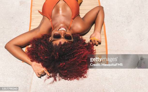 bronceado de la mujer afro - tomar sol fotografías e imágenes de stock