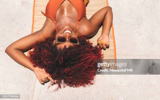 afro woman tanning - sunbathing stock pictures, royalty-free photos & images