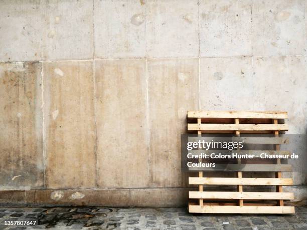 empty wooden pallet and wall on a sidewalk in paris - pallet industrial equipment stock-fotos und bilder