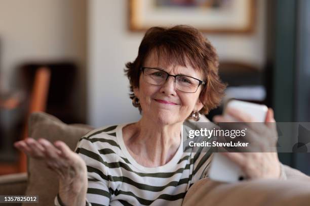 femme avec téléphone ayant des problèmes - indécision photos et images de collection