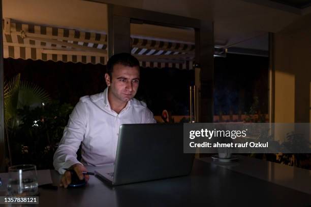 young office worker aged 25-30 continues to work from a laptop when there is a power cut - internet outage stock pictures, royalty-free photos & images
