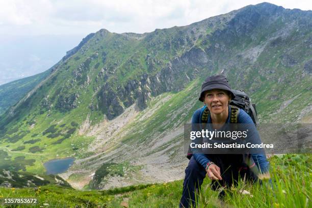 woman enjoying for a day hiking in the mountains climbing traveler, hiker, mountaineer. - alps romania stock pictures, royalty-free photos & images