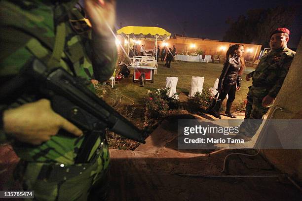 An Iraqi Army special forces soldier keeps watch at a women's art exhibition sponsored by Iraqi Parliament member Safi Asiheil in a posh Baghdad...