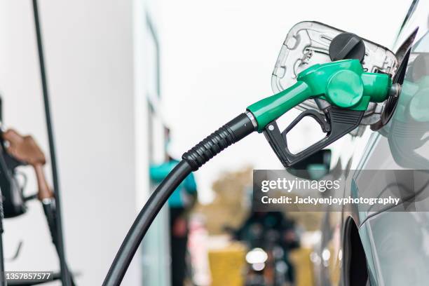 hand refilling the car with fuel, close-up. - gasoline fotografías e imágenes de stock