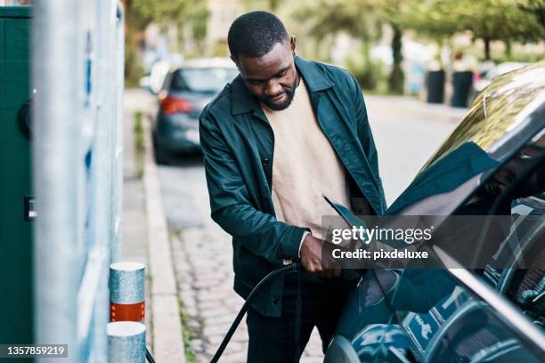 cropped shot of a handsome young man recharging his electric car at a gas station - car scandinavia stock pictures, royalty-free photos & images