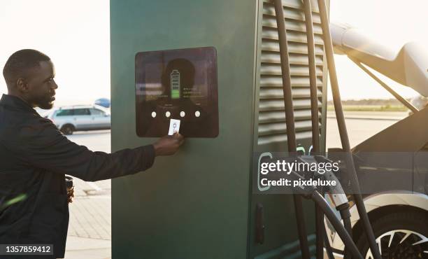 cropped shot of a handsome young man recharging his electric car at a gas station - car nfc stock pictures, royalty-free photos & images