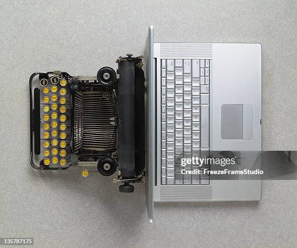 clásico analógico máquina de escribir vs. moderno digital portátil hi-tech - el milenio fotografías e imágenes de stock