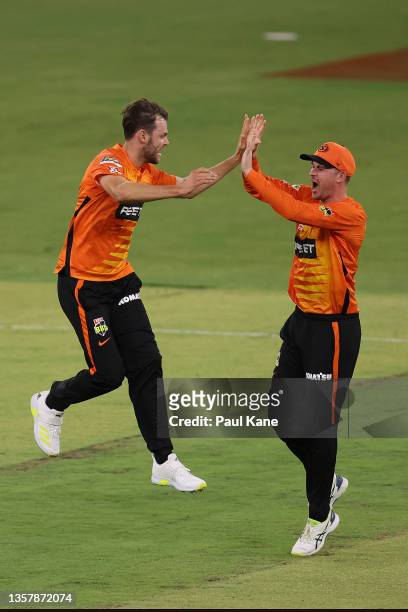 Matt Kelly and Ashton Turner of the Scorchers celebrate the wicket of Ben Duckett of the Heat during the Men's Big Bash League match between the...