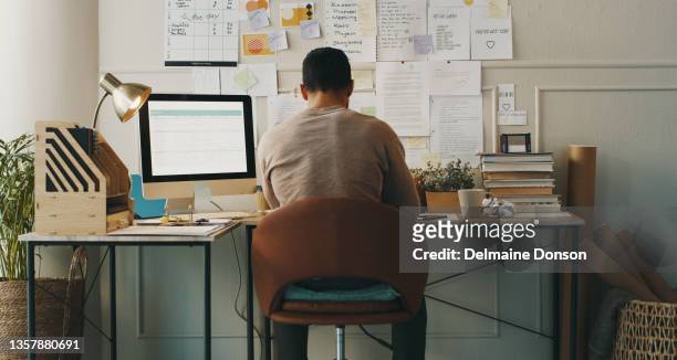 tiro de um empresário irreconhecível sentado sozinho enquanto trabalhava em casa - back shot position - fotografias e filmes do acervo