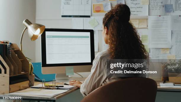 shot of an unrecognisable businesswoman sitting alone and using her computer while working from home - woman on computer stock pictures, royalty-free photos & images