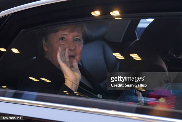 Former German Chancellor Angela Merkel waves goodbye as she departs from the Chancellery for the last time following the official transfer of office...