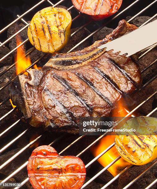 grilling sirloin steak and fresh vegetables with charcoal flames - seared stockfoto's en -beelden