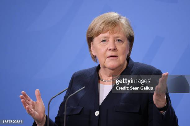 Former German Chancellor Angela Merkel speaks as new Chancellor Olaf Scholz listens during the official transfer of office at the Chancellery on...