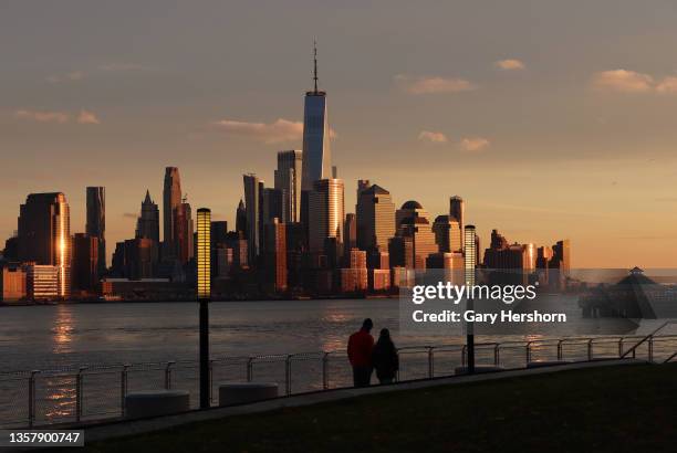 The sun sets on lower Manhattan and One World Trade Center in New York City on the day the sun set at its earliest possible time of the year on...