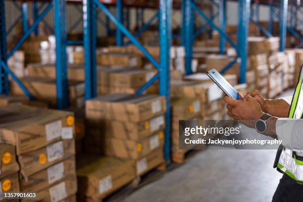 warehouse worker in uniform is inspecting shipment for delivering to customers. - electronic store stock pictures, royalty-free photos & images