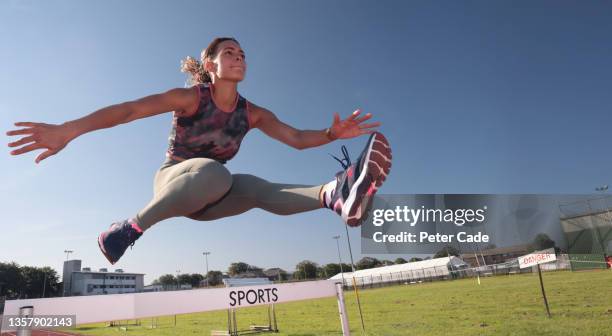 woman jumping over hurdle - devon winer stockfoto's en -beelden