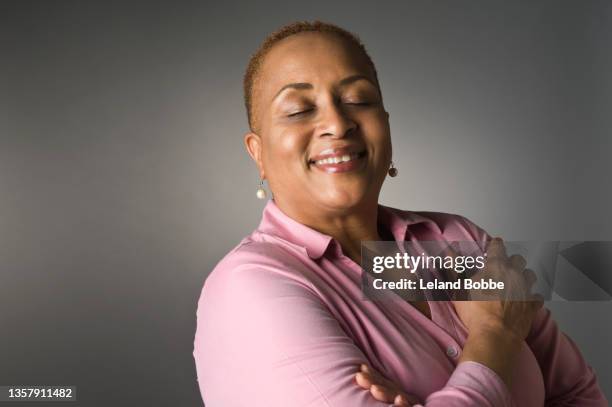 studio portrait of middle aged african american female - krama sig själv bildbanksfoton och bilder