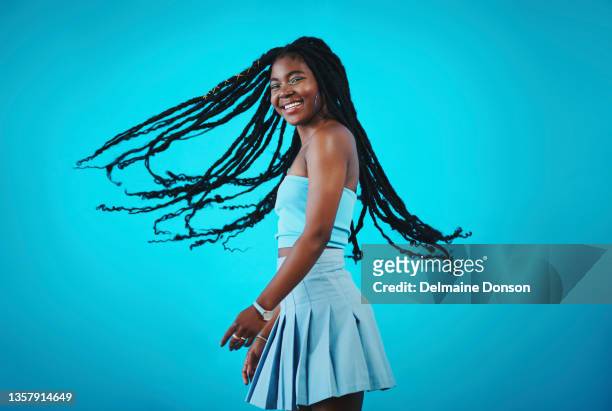 photo d’une belle jeune femme secouant les cheveux debout sur un fond bleu - tressé photos et images de collection