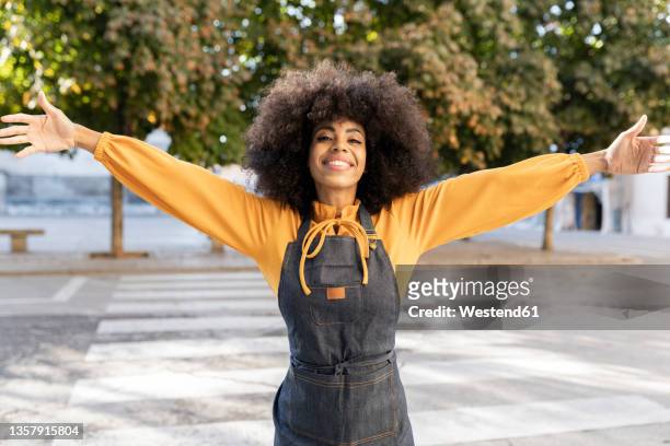 happy waitress with arms outstretched on footpath - arms outstretched fotografías e imágenes de stock