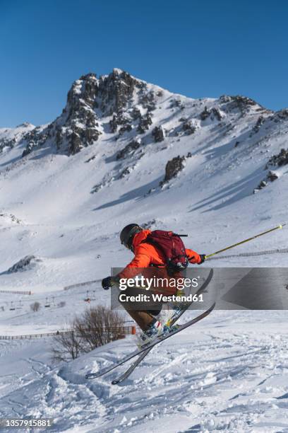 tourist with backpack skiing on snowcapped mountain - ski jump stock pictures, royalty-free photos & images