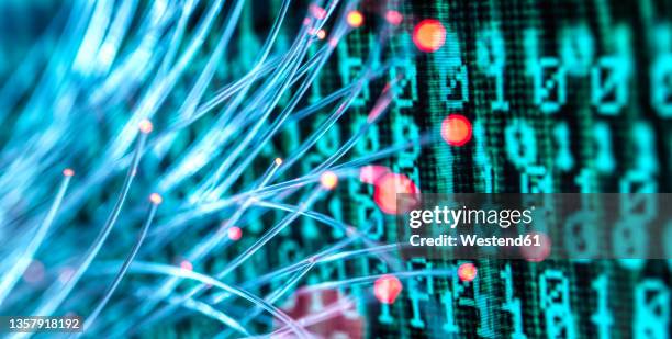 fiber optics carrying computer virus attacking binary code - cybercrime stock-fotos und bilder