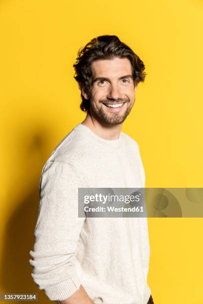 handsome businessman smiling on yellow background - three quarter length stock pictures, royalty-free photos & images