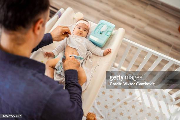 young father changing diapers - wet wipe stock pictures, royalty-free photos & images