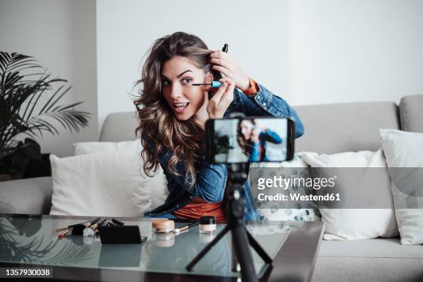 influencer applying mascara at home studio - influencers stock pictures, royalty-free photos & images