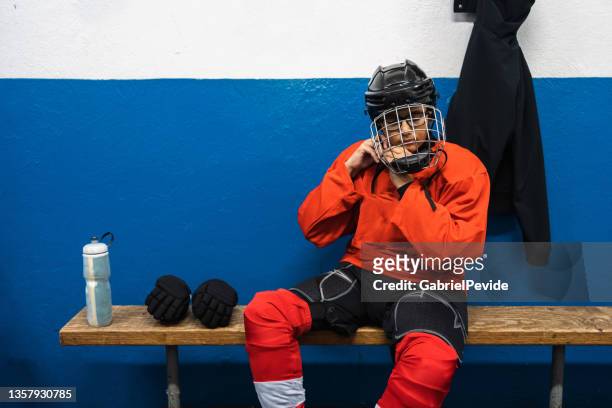ragazzo che si prepara a praticare l'hockey - hockey su ghiaccio foto e immagini stock