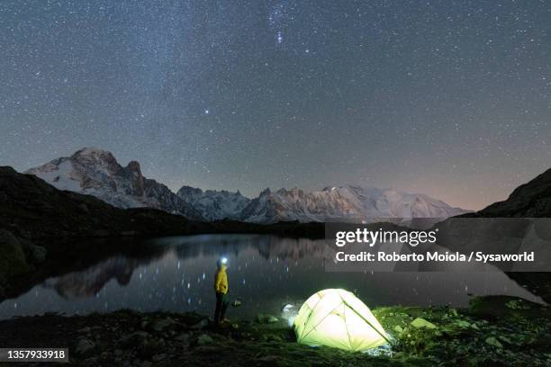 hiker at lake chesery admiring mont blanc at night - lake chesery stockfoto's en -beelden