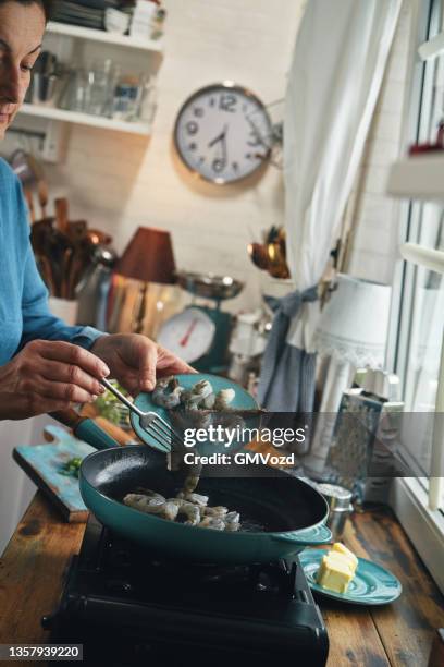 preparing shrimp and grits in domestic kitchen - shrimp and grits stock pictures, royalty-free photos & images