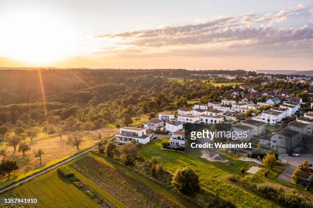 germany, baden-wurttemberg, baltmannsweiler, aerial view of sun setting over new development area in schurwald - detached house stock pictures, royalty-free photos & images
