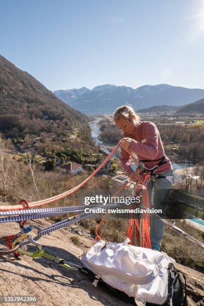 woman belaying rock climber from below - zekeren stockfoto's en -beelden