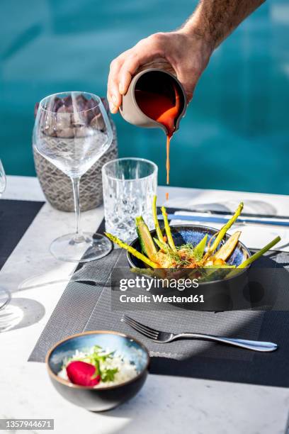 Chef Pouring Sauce On Salad At Table High-Res Stock Photo