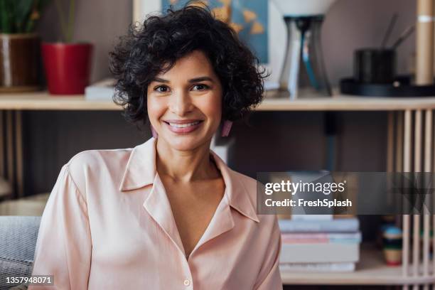 a beautiful african-american woman smiling while looking at camera - nutritionist stock pictures, royalty-free photos & images