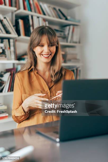 cheerful businesswoman talking on video call meeting - yellow shirt stock pictures, royalty-free photos & images